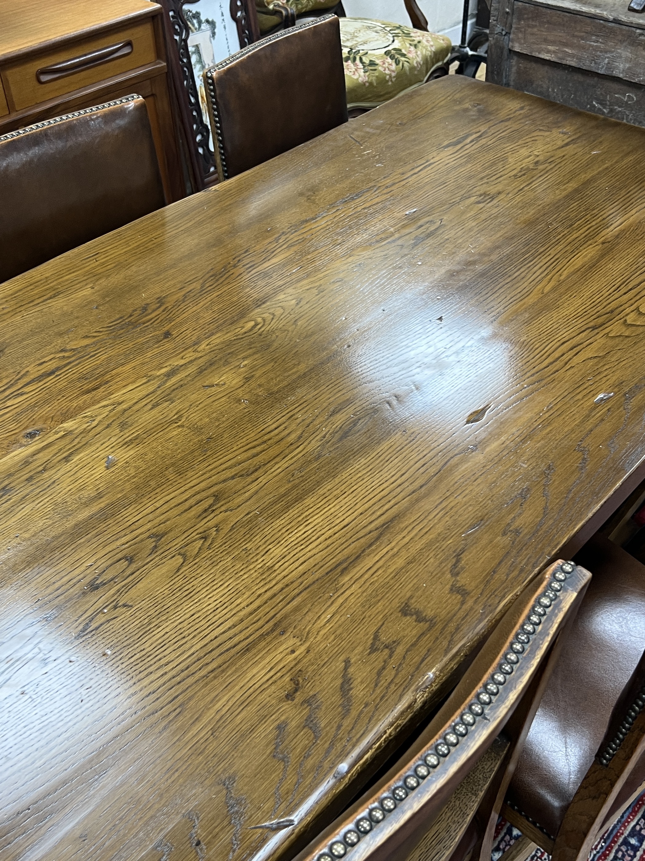 An 18th century style oak refectory dining table, length 198cm, height 76cm and eight oak dining chairs, two with arms